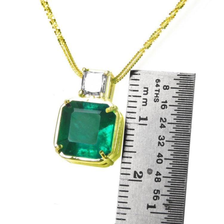 18K yellow gold necklace with a large asscher cut Colombian emerald and a princess cut diamond.