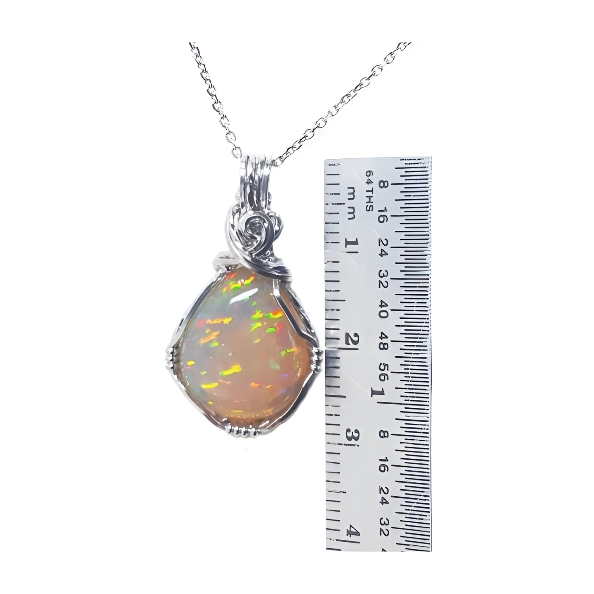 5.96 ct. Welo Ethiopian multicolor opal pendant with silver wire wrap setting, next to a ruler.