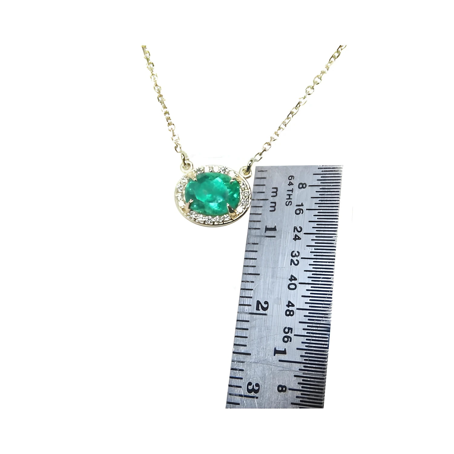 0.90 carat oval Muzo emerald necklace in 14K yellow gold, shown with a ruler for scale.