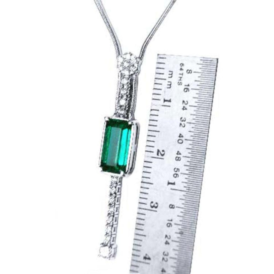 White gold necklace with a rectangular Colombian emerald and diamond accents, shown next to a ruler.