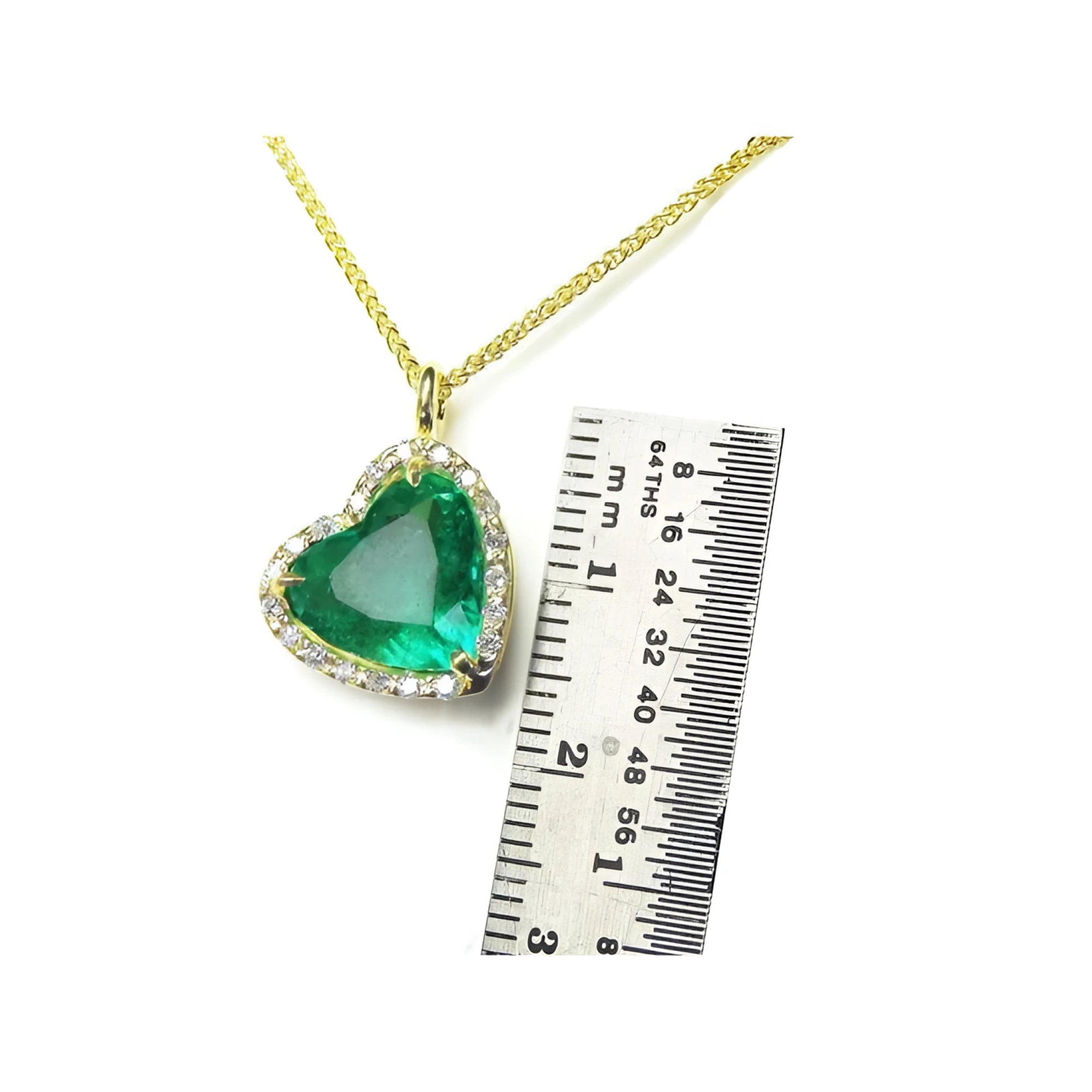 Tilted heart emerald necklace with halo diamonds on an 18K gold chain, shown with a ruler for scale.