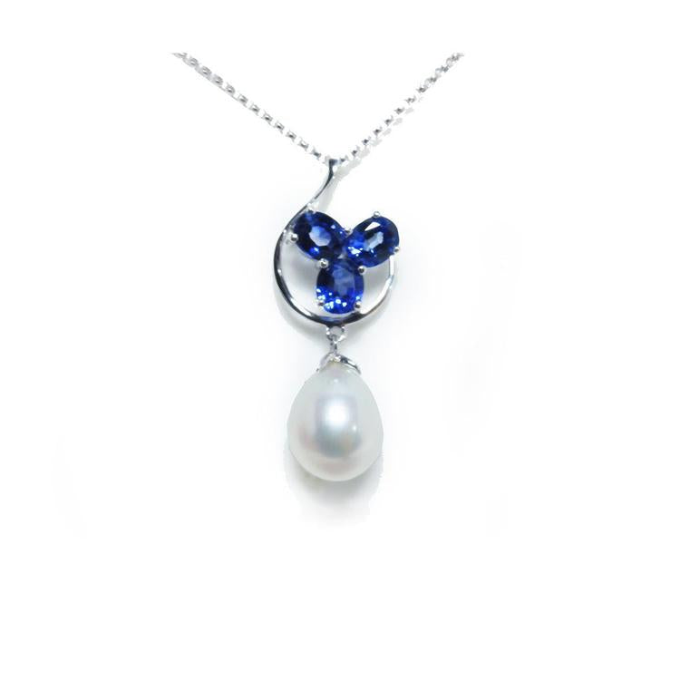 Front position of a natural sapphire cluster necklace pendant and dangling pearl white gold, top side view