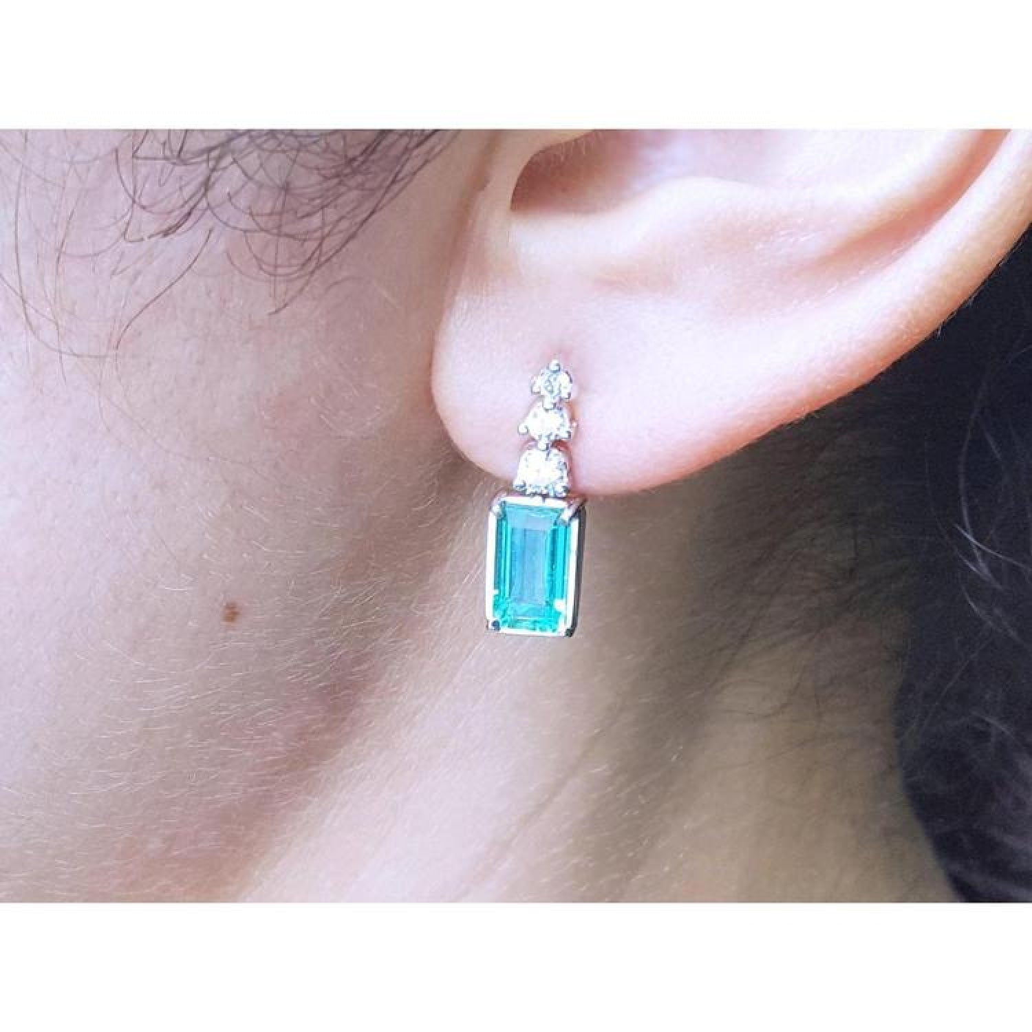 14K white gold earring with rectangular emerald and three round diamonds.