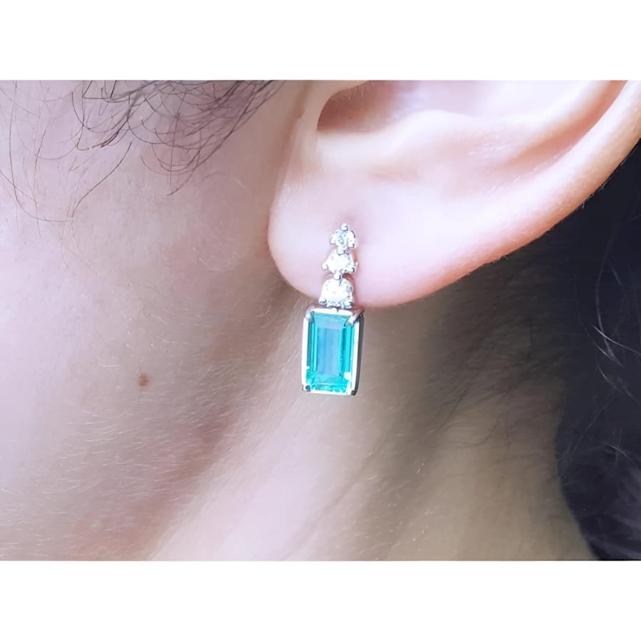 14K white gold earring with rectangular emerald and three round diamonds.