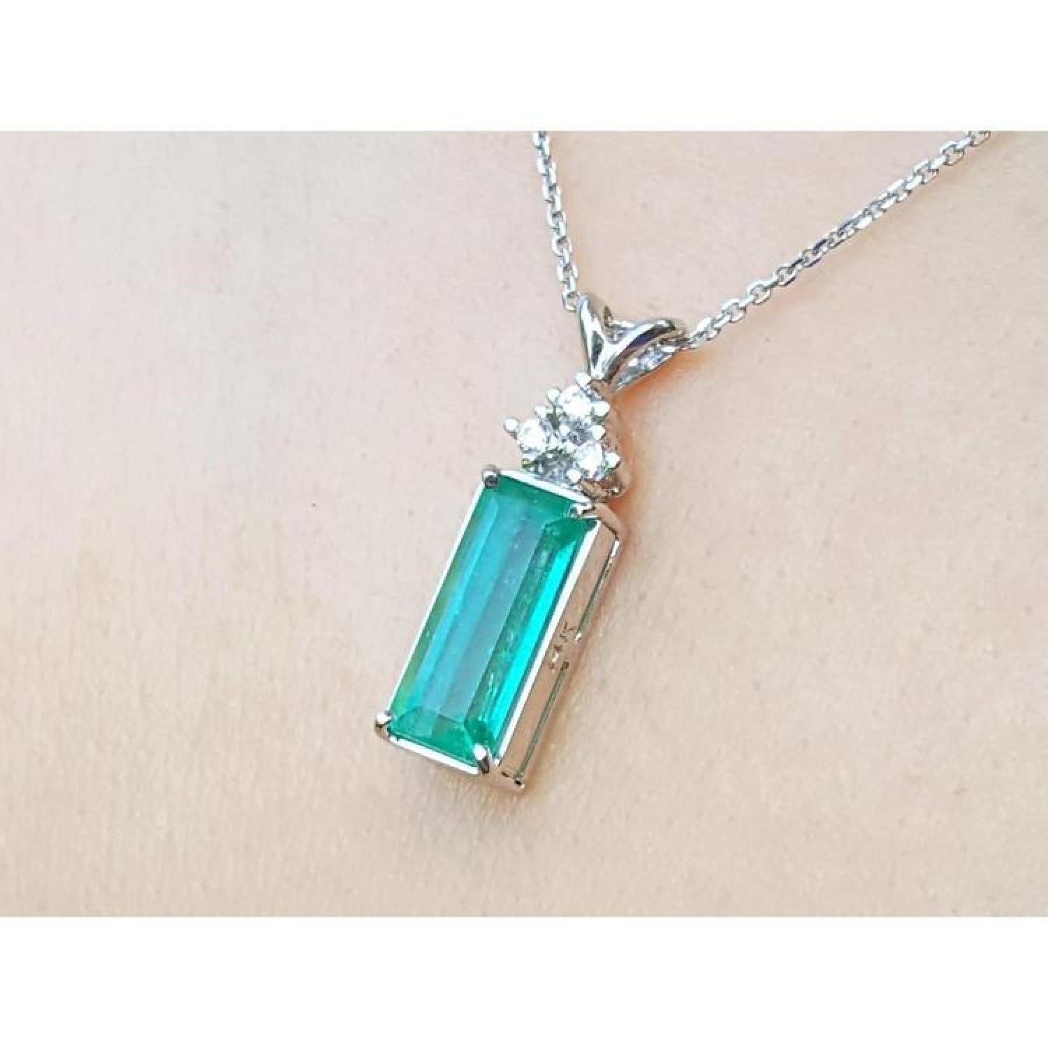Emerald pendant with accent diamonds in 14K white gold on a delicate chain.