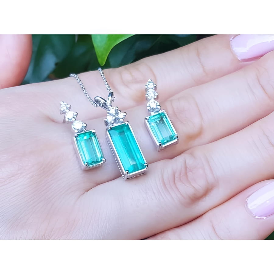 Emerald earrings and pendant set with accent diamonds in 14K white gold.
