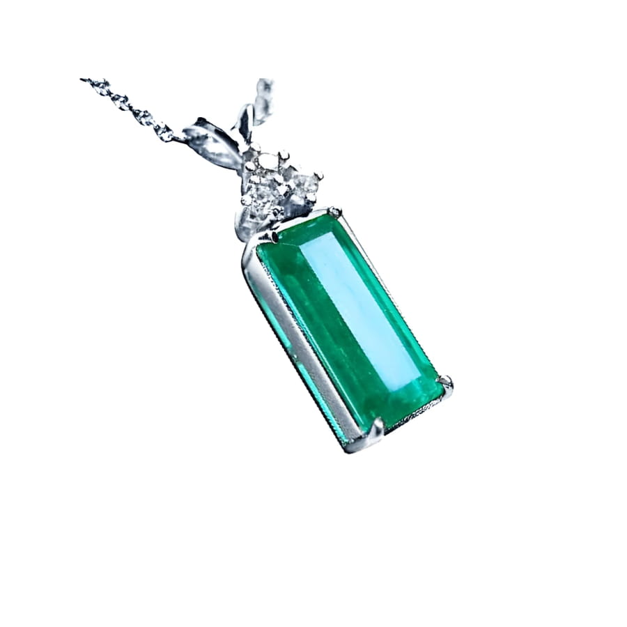Emerald pendant with a rectangular medium bluish-green emerald and diamond accents in 14K white gold.