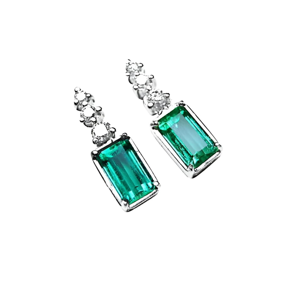 14K white gold dangle earrings with rectangular medium bluish-green emeralds and diamond accents.