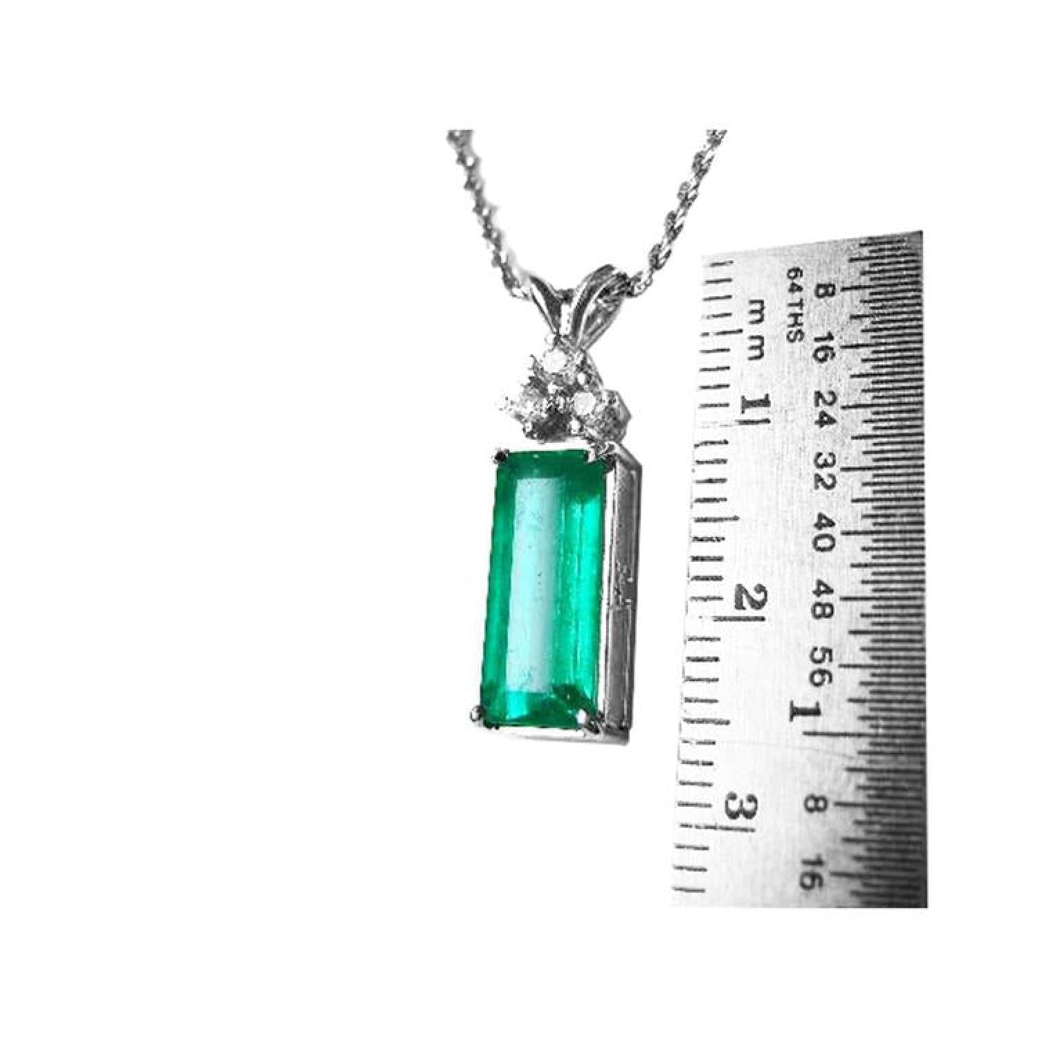 White gold pendant with a rectangular emerald and diamond accents, measured against a ruler.