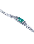 White gold bracelet with a rectangular emerald gemstone on a side profile position.