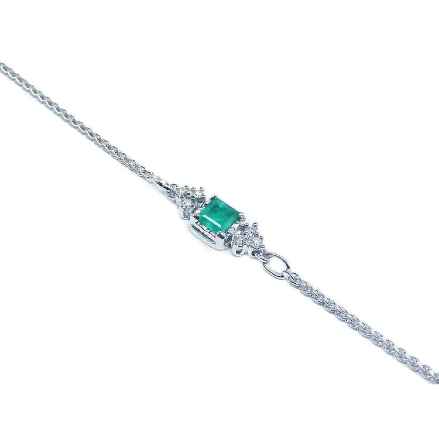 14K white gold bracelet with a central emerald-cut Colombian emerald and diamond accents.