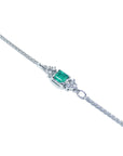 The side profile of a white gold emerald and diamond bracelet.