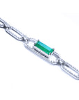 The side profile of a paperclip style bracelet with an emerald-cut natural emerald on a white background.