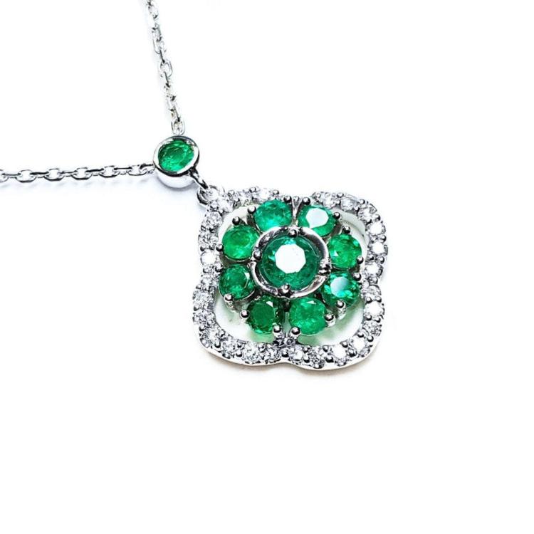 A natural emeralds necklace cluster set within a delicate 4-leaf clover design, crafted in 14k white gold and diamonds.