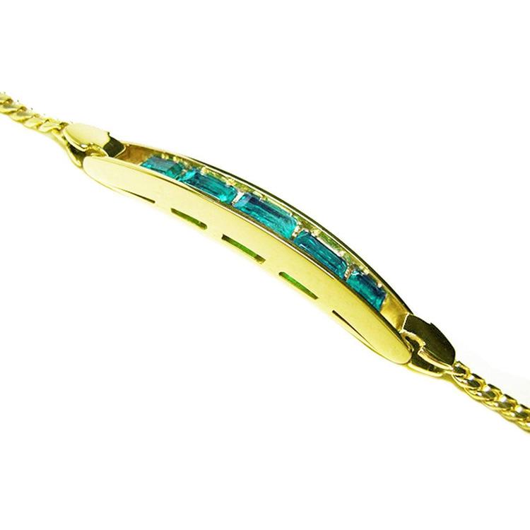 The sideview of a gold bracelet natural colombian emeralds on a white background.