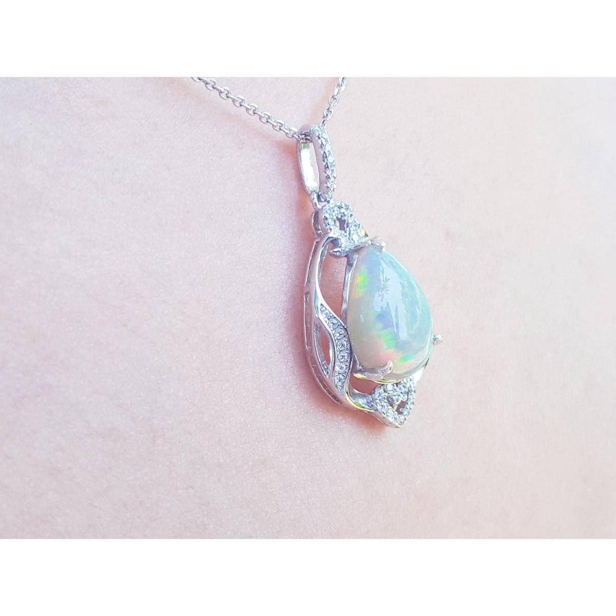 Opal pendant necklace on a pink skin background.