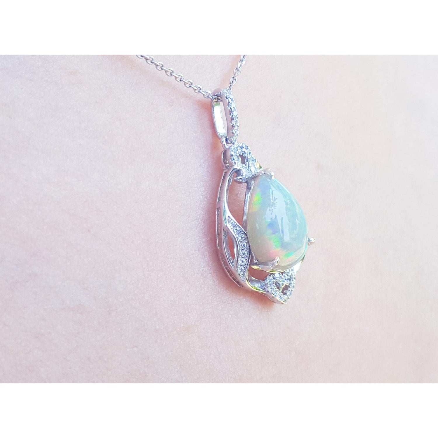 Opal pendant necklace on a pink skin background.