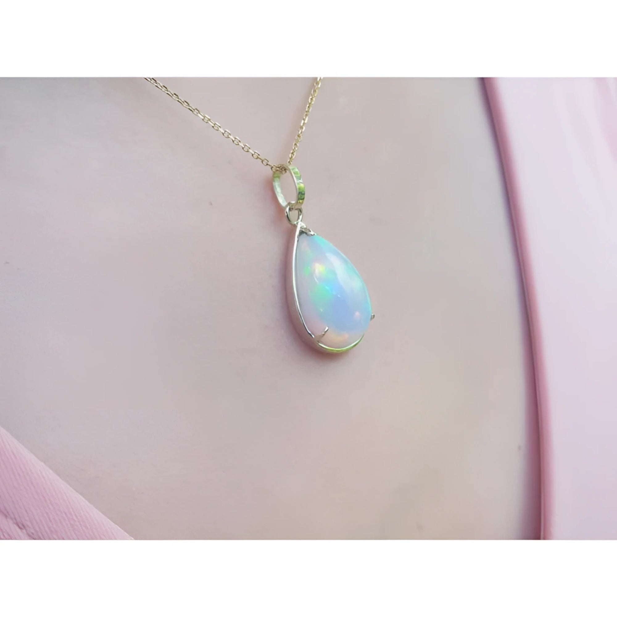 Radiant 9.29 ct. Ethiopian Welo opal pendant in 14K solid yellow gold, worn on a pink top.