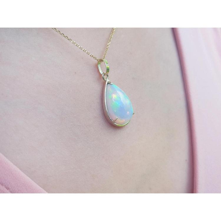 Radiant 9.29 ct. Ethiopian Welo opal pendant in 14K solid yellow gold, worn on a pink top.