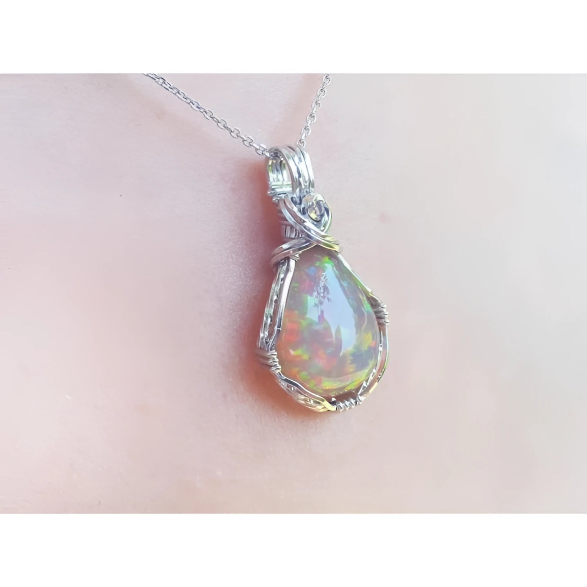 Welo Ethiopian multicolor opal pendant with a pear-shaped stone in a handmade silver wire wrap setting.