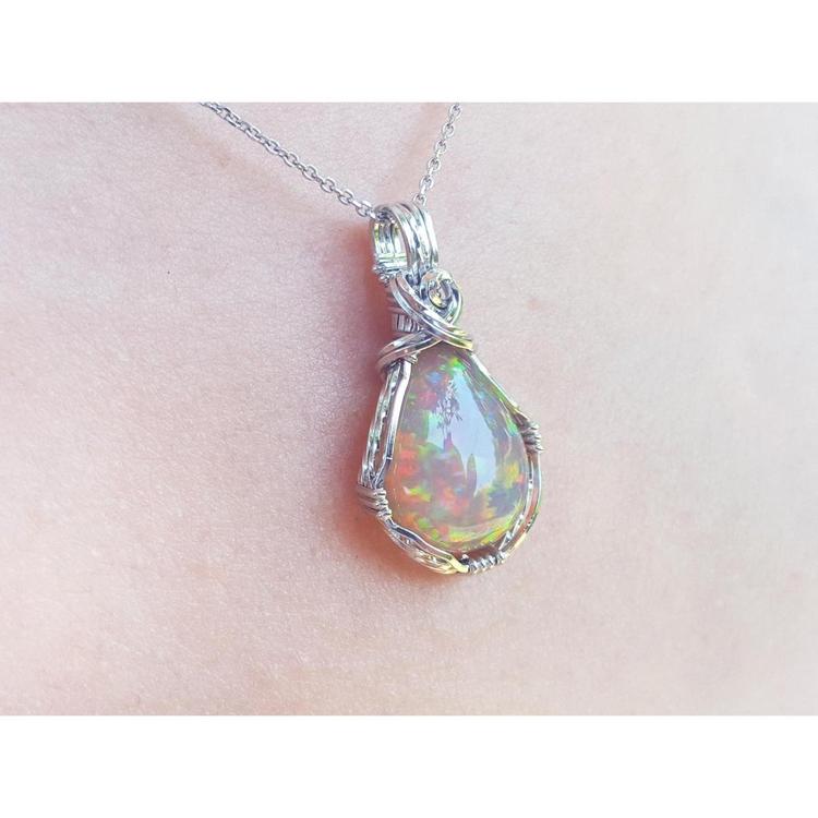 Welo Ethiopian multicolor opal pendant with a pear-shaped stone in a handmade silver wire wrap setting.
