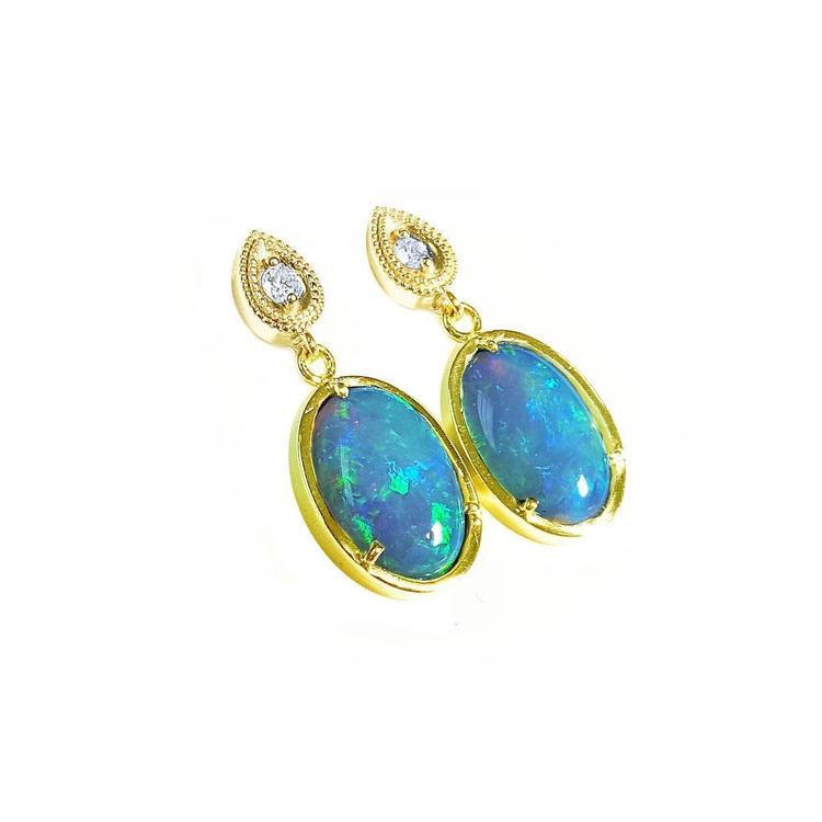 Opal earrings with gold setting and small diamonds on a right profile view.