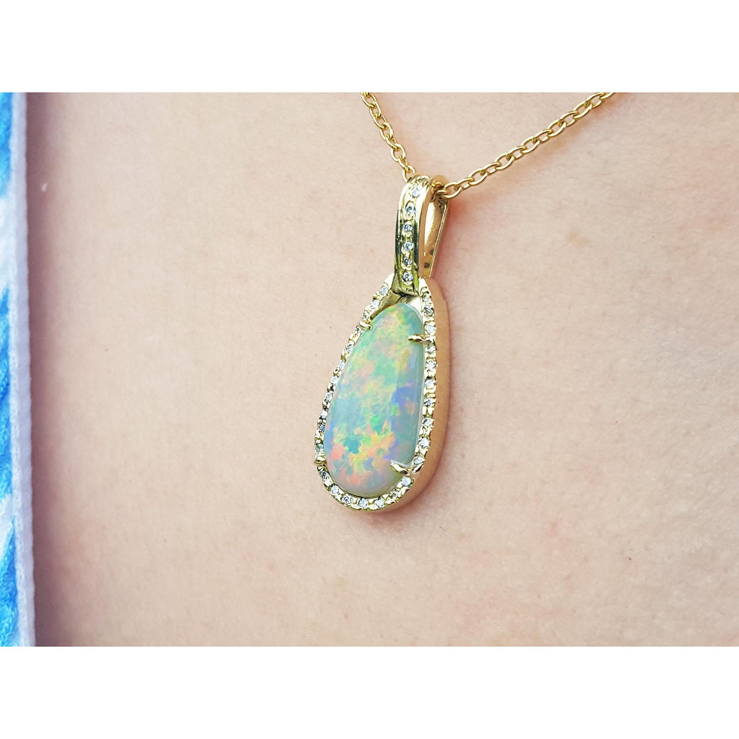 Opal pendant necklace on a person&#39;s neck against a neutral background