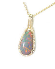 Opal pendant necklace on a gold chain displaying the topside with a gold and diamonds frame.