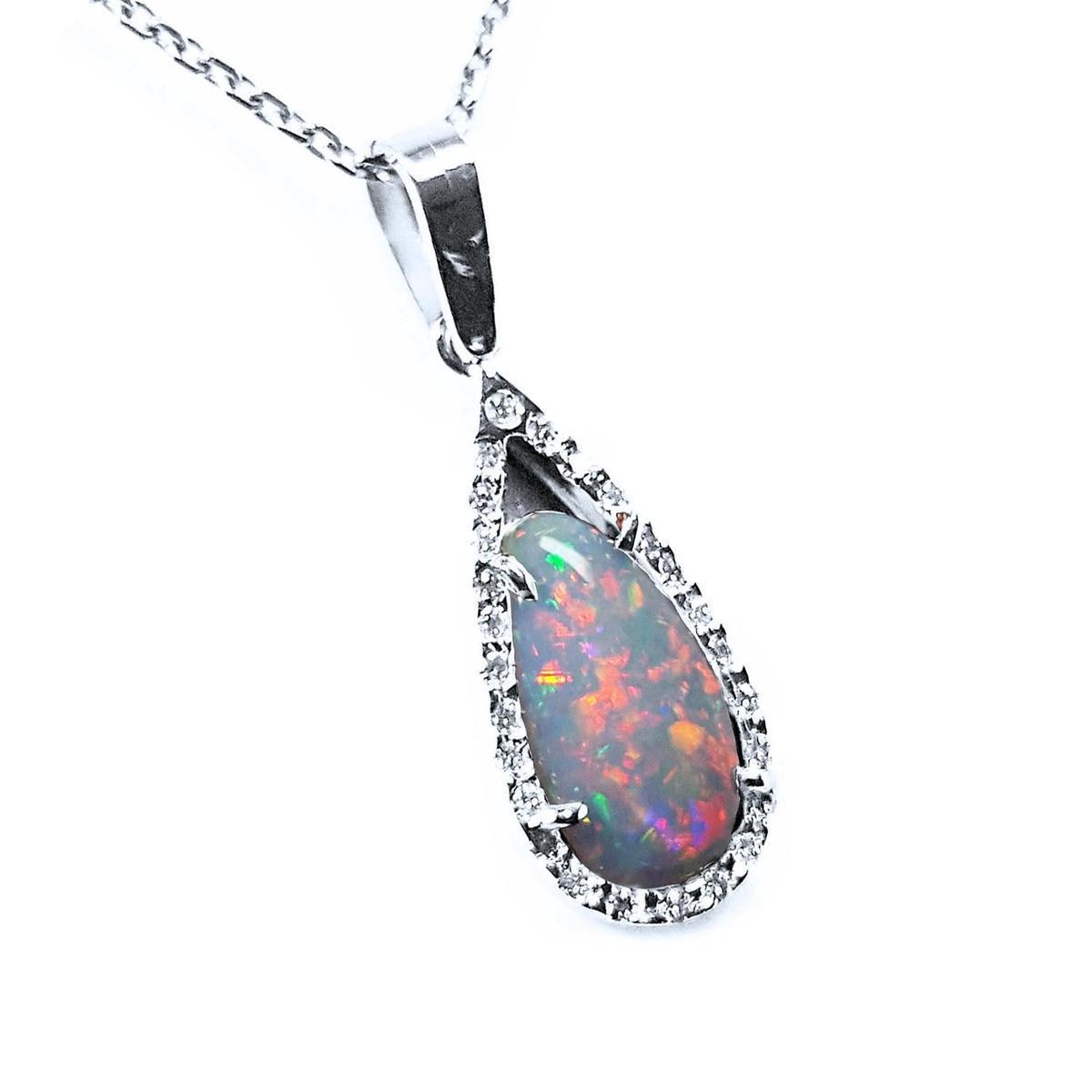 A solid natural Australian pear red opal surrounded by a halo diamond in white gold pendant, shows its right-side profile.