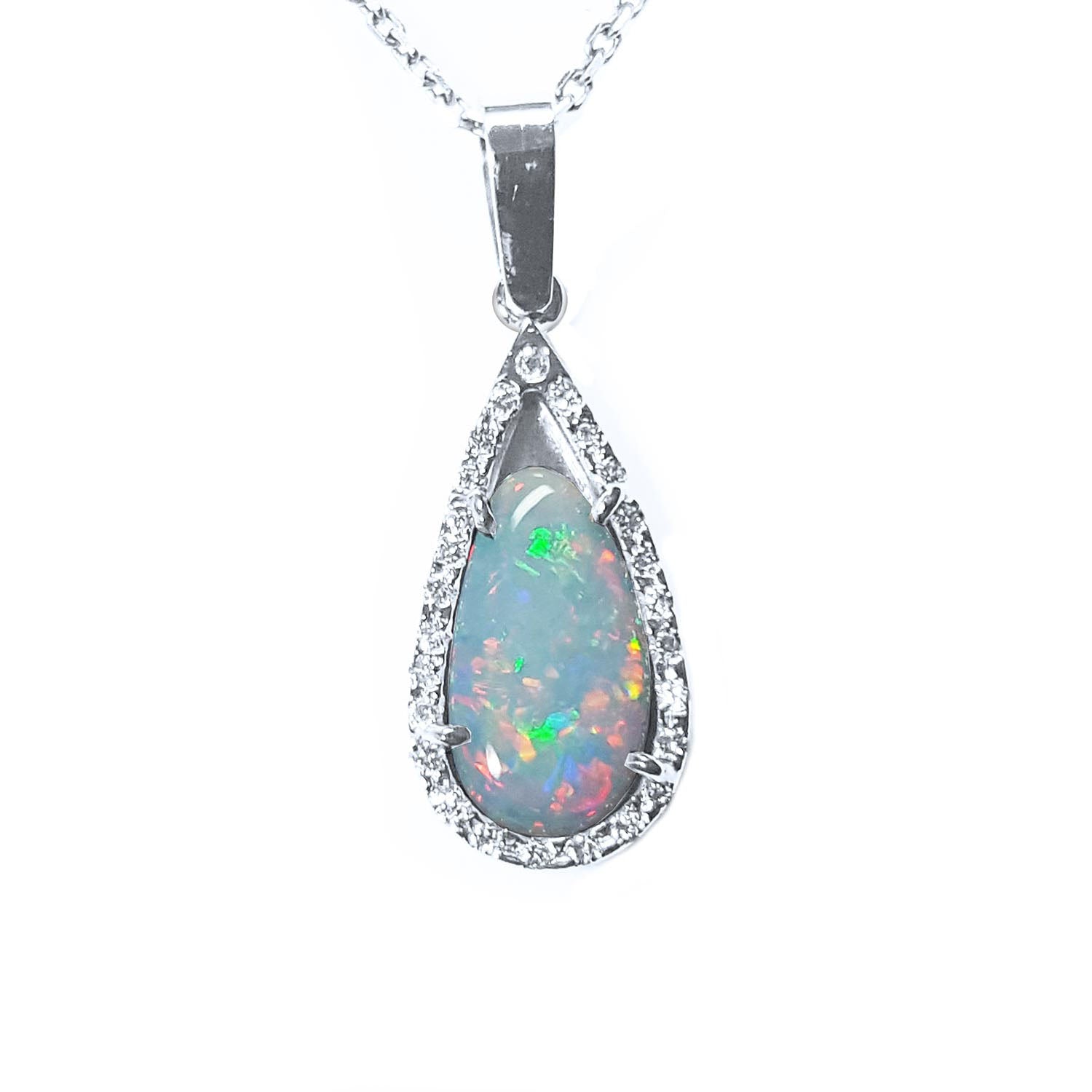 This pear opal pendant necklace displays a white gold and diamond frame on a topside view.