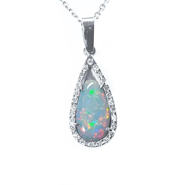 This pear opal pendant necklace displays a white gold and diamond frame on a topside view.