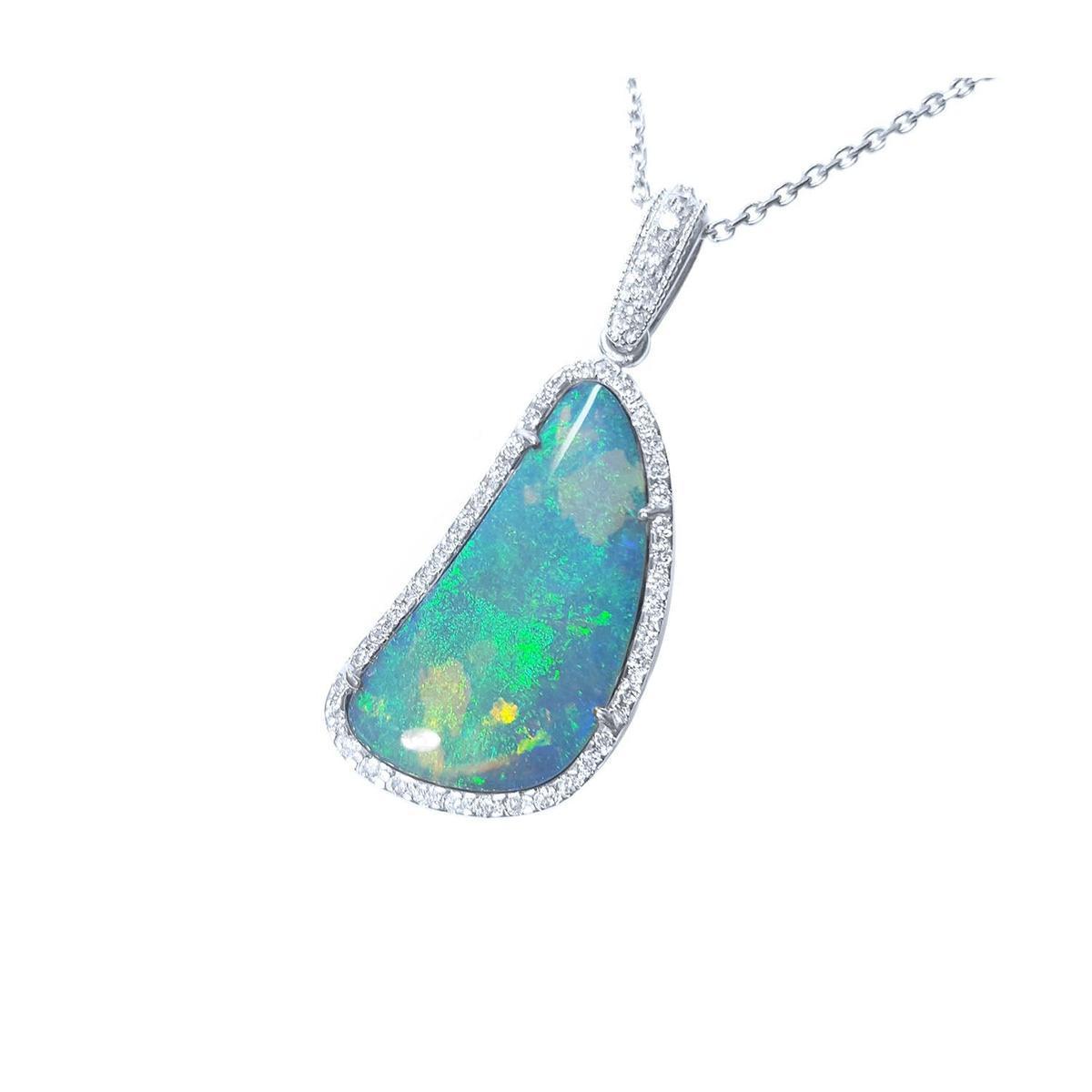 This solid Australian opal is surrounded by a halo of natural diamonds in a white gold frame pendant.