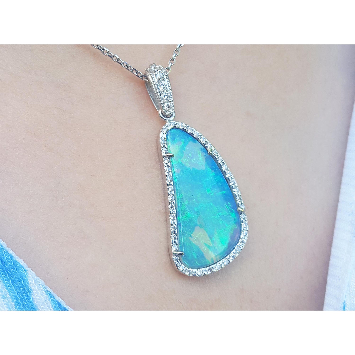 Opal pendant necklace on a person&#39;s neck with a blurred background