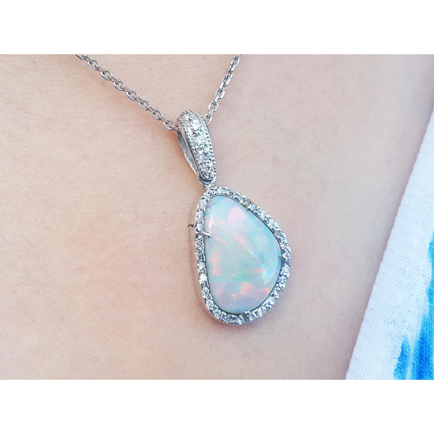 Opal pendant necklace on a person&#39;s neck with a blurred background