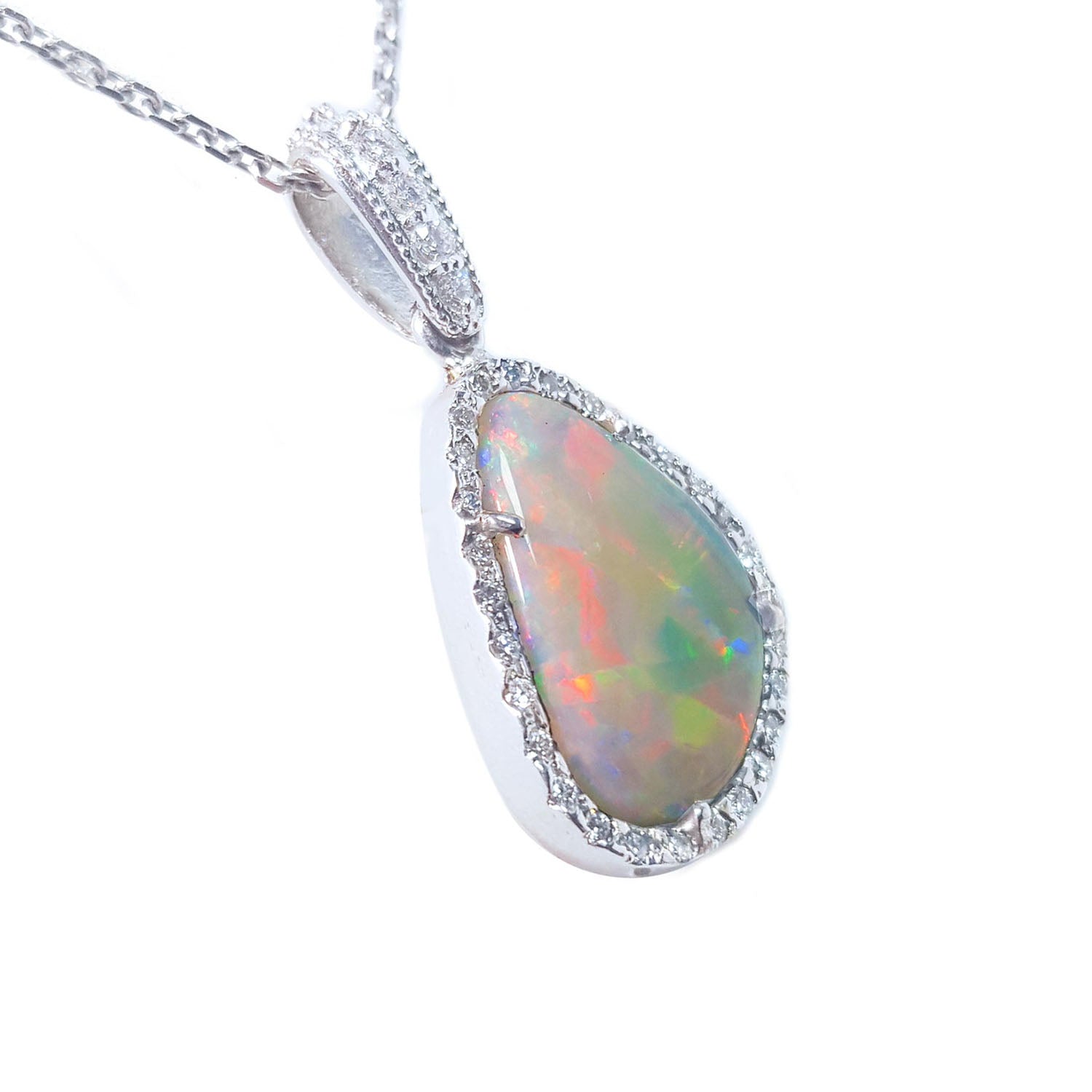 A white solid Australian opal surrounded by a frame with diamonds on a gold chain displaying its righ-side profile.