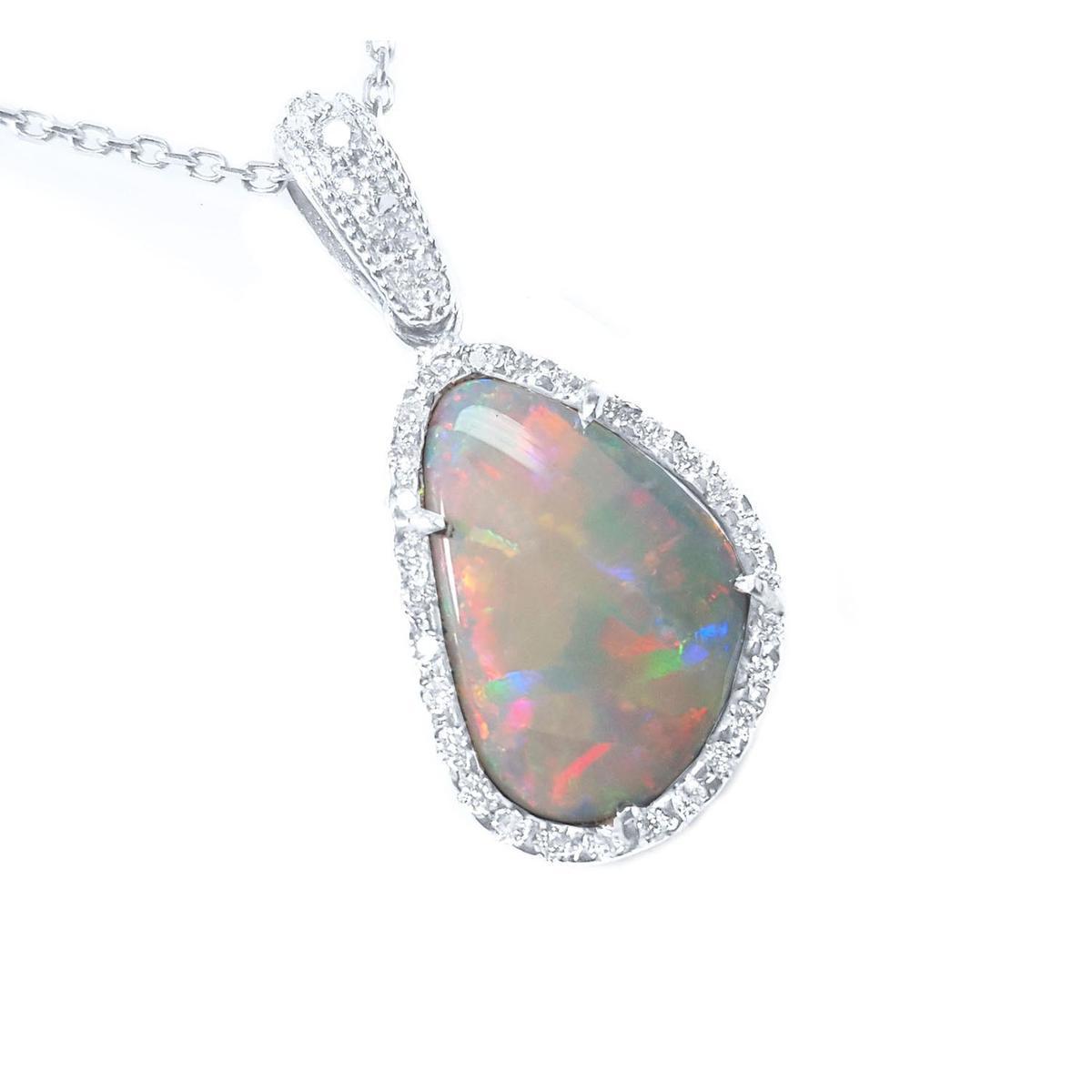A solid Australian opal pendant in white gold with diamond accents on a white background