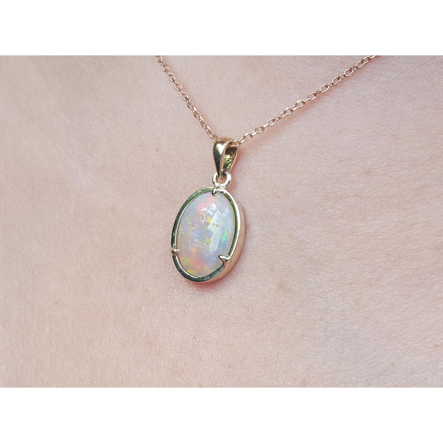 Opal pendant necklace on a light pink background
