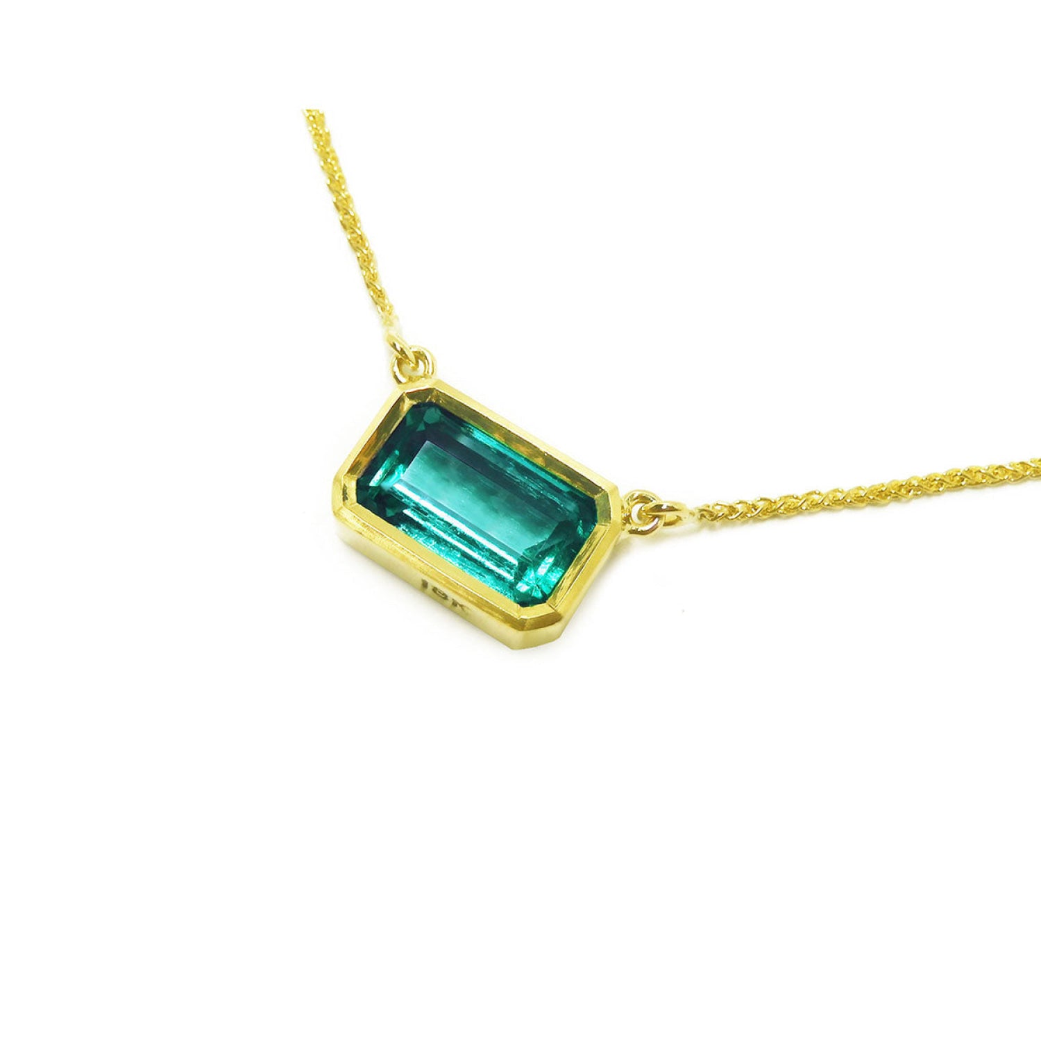 East-west rectangular emerald solitaire necklace in 18K yellow gold.