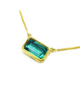East-west rectangular emerald solitaire necklace in 18K yellow gold.