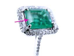 spotting a surface reaching natural flaw pore on emerald gemstone 