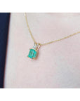 1.71 ct emerald-cut emerald pendant in 14K yellow gold with diamond accent on a delicate chain.
