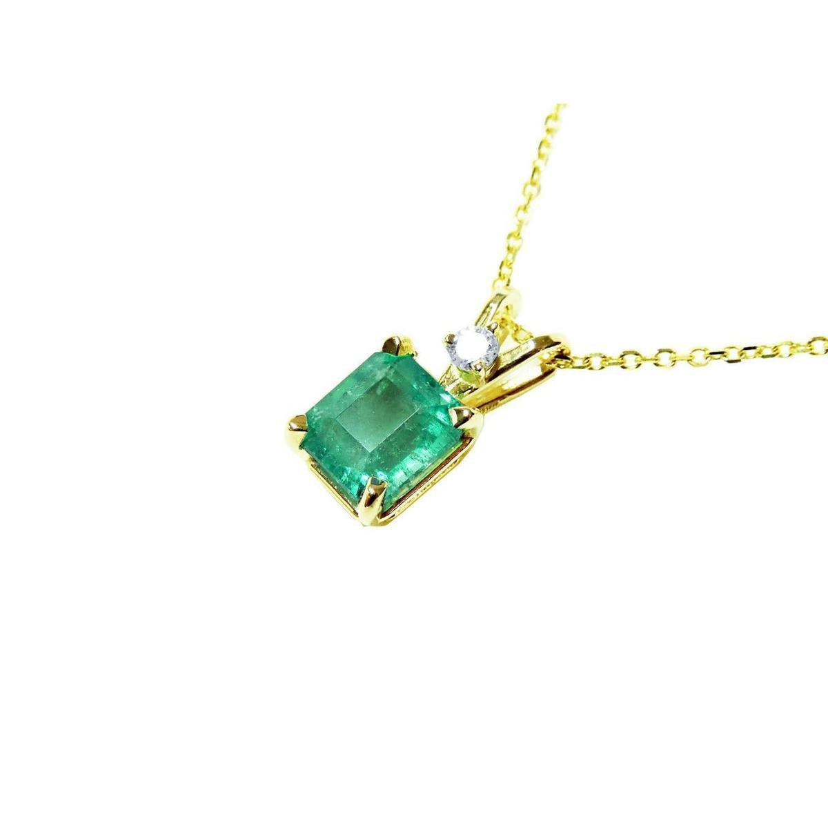 Gold necklace with a natural colombian emerald pendant on a left-side position topside view.