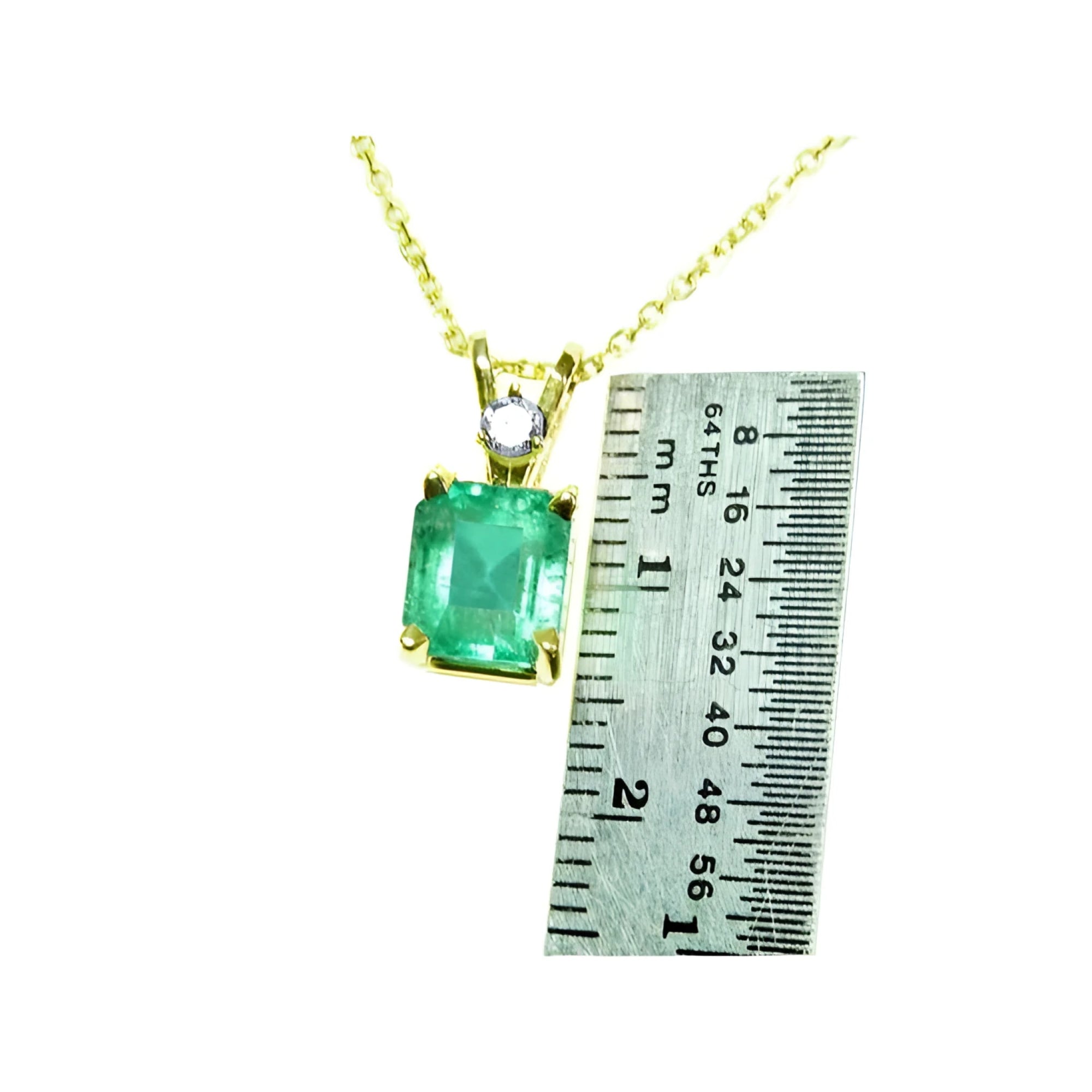Emerald-cut emerald pendant in 14K yellow gold with diamond accent, shown next to a ruler.