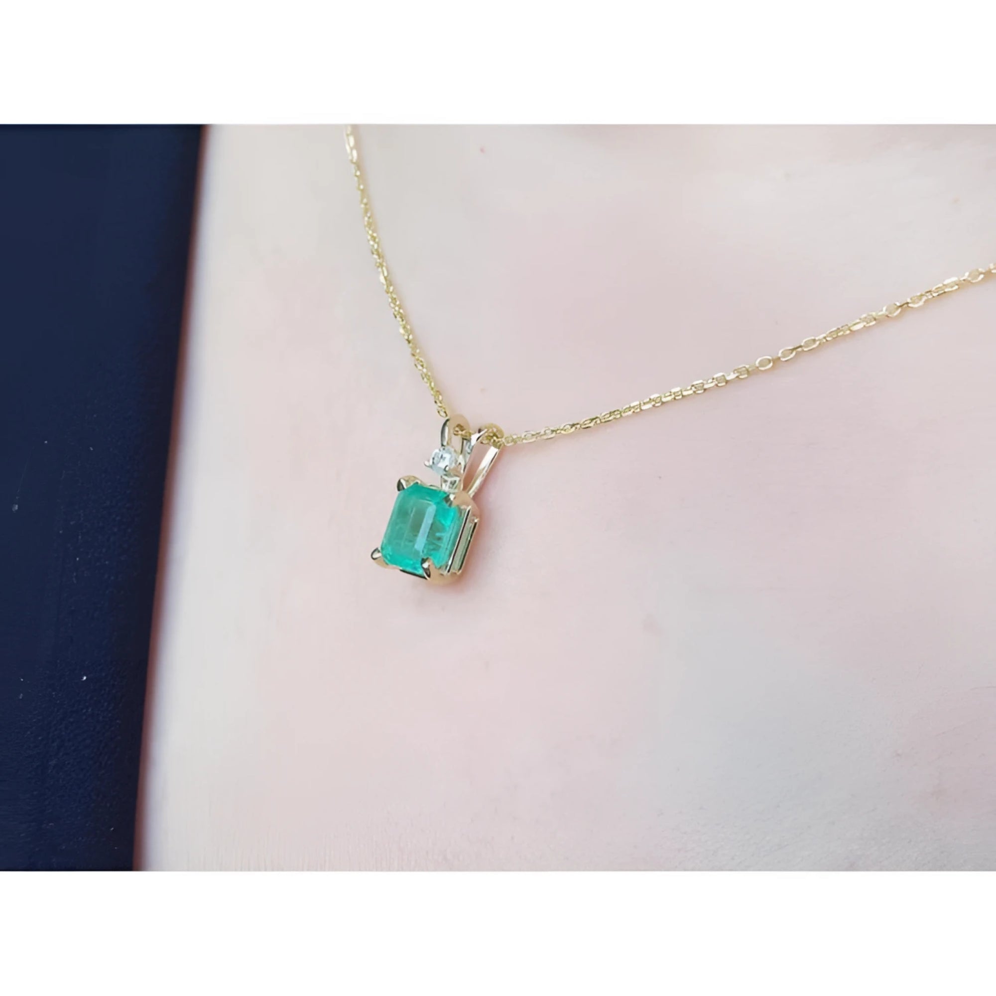 1.71 ct emerald-cut emerald pendant in 14K yellow gold with diamond accent on a delicate chain.