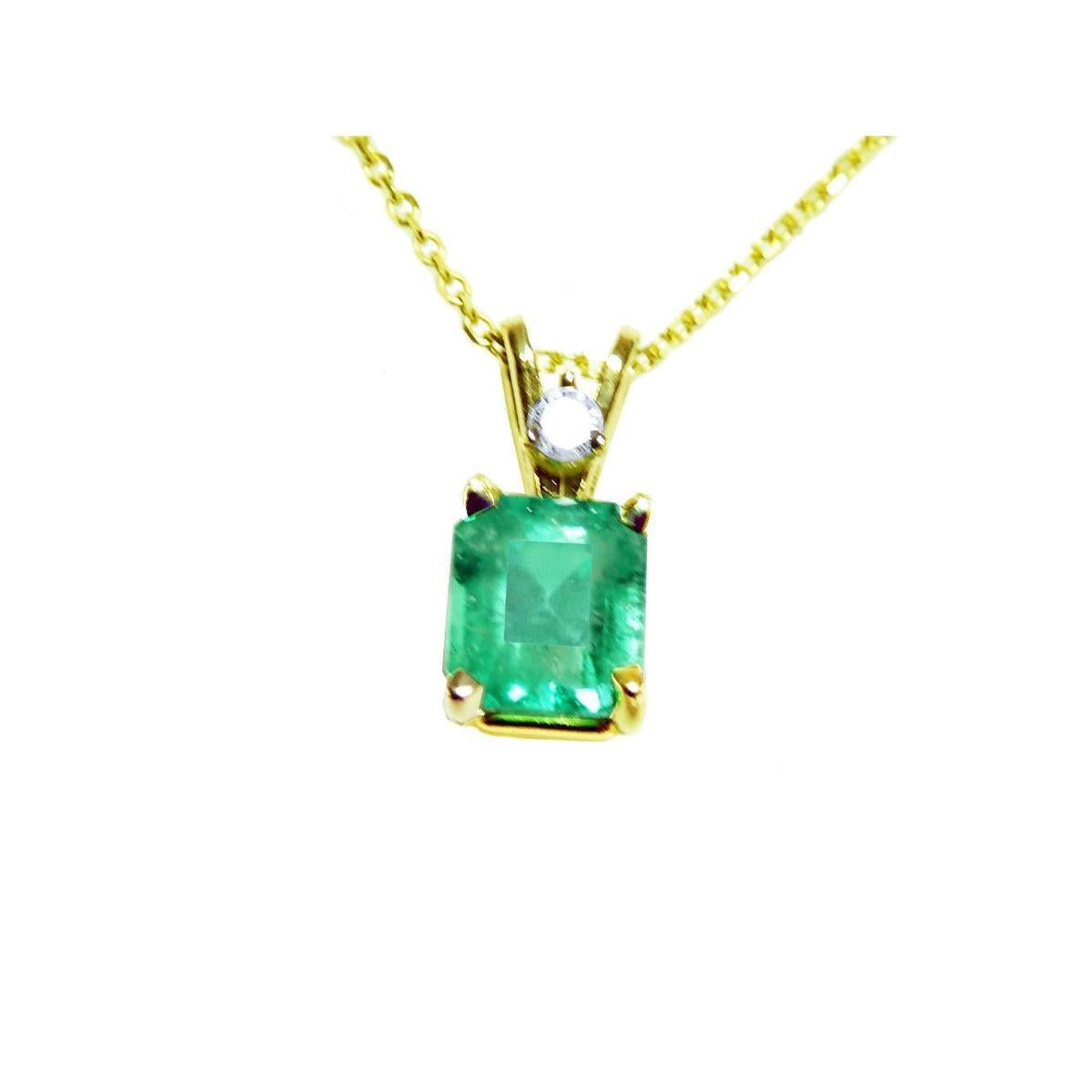 This natural emerald-cut colombian emerald pendant made of yellow gold is showing its topside.