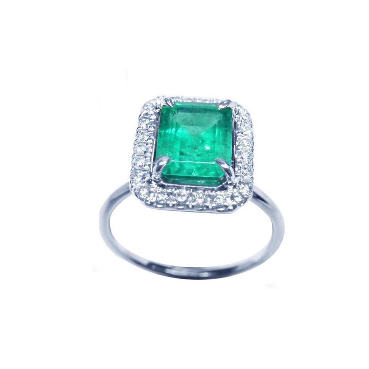 Radiant emerald-cut bluish-green emerald ring with halo diamonds in 14K white gold.
