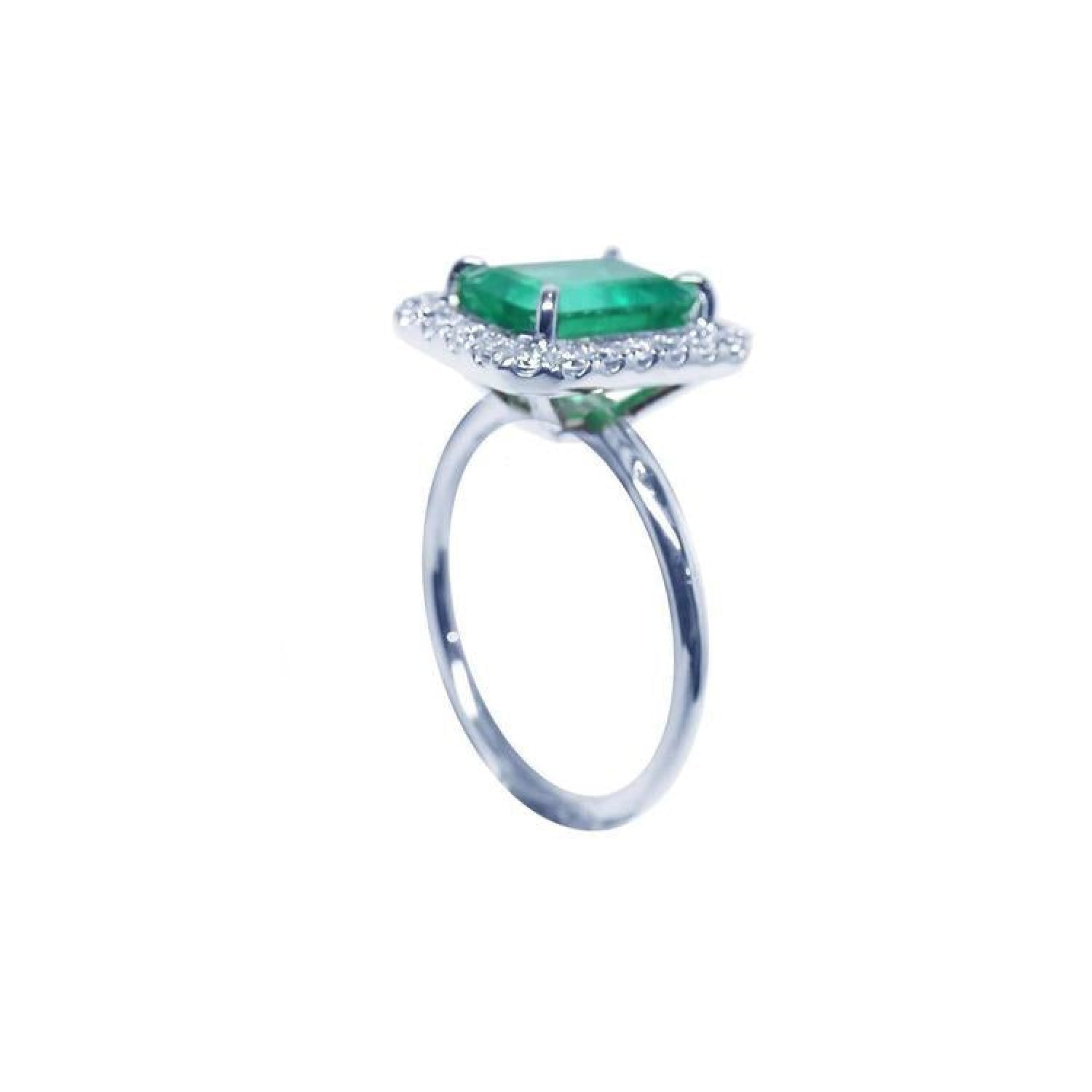 Emerald-cut emerald ring with halo diamonds in 14K white gold.
