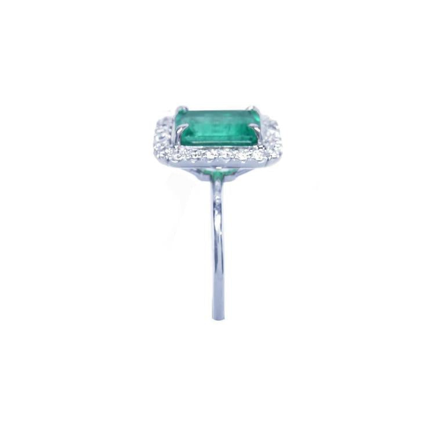 Emerald-cut bluish-green emerald ring with halo diamonds in 14K white gold.