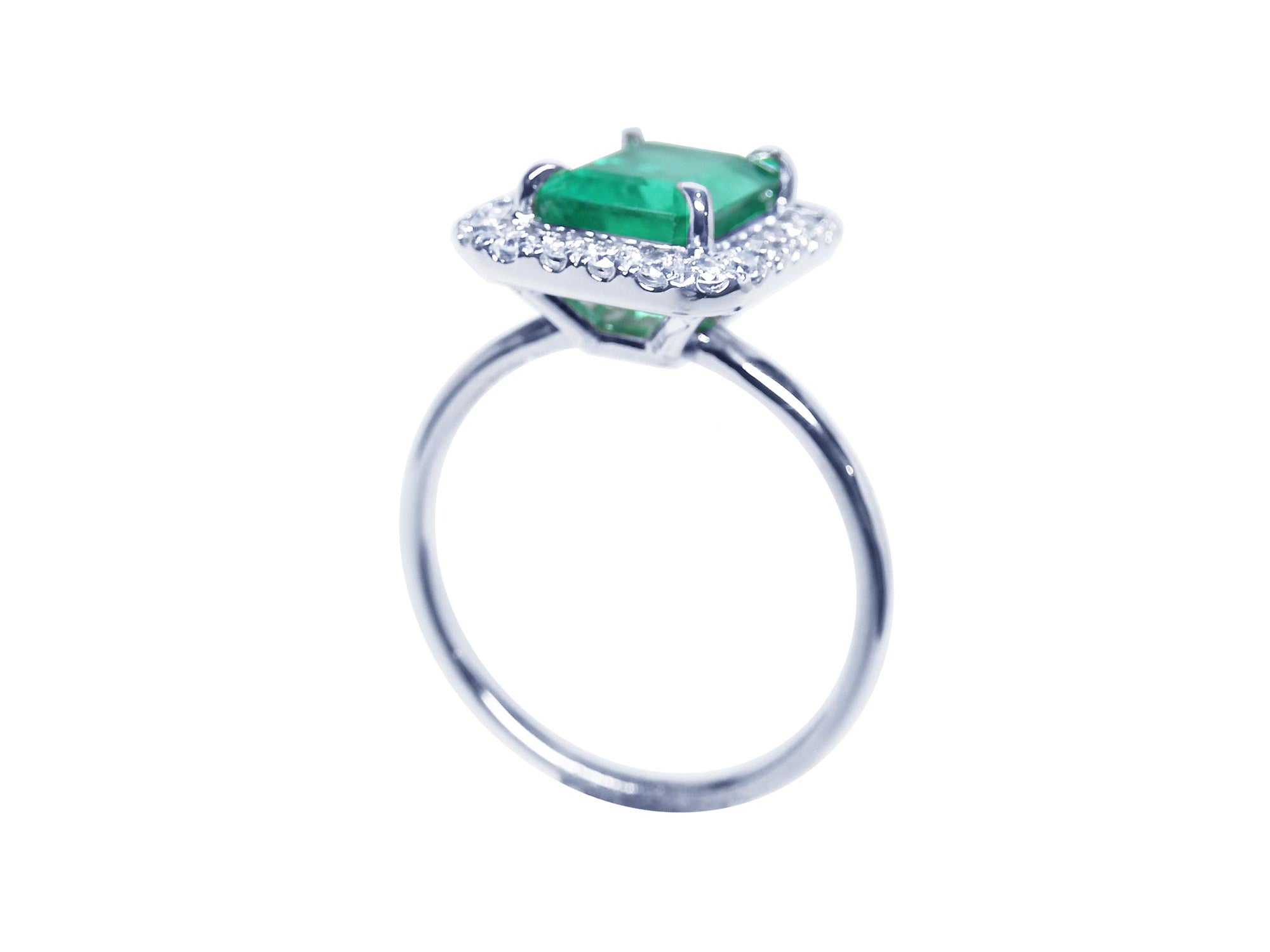 A 14k white gold emerald ring for women on its lateral underside profile top, gallery and band view.