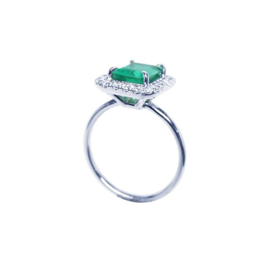 Emerald-cut emerald ring with halo diamonds in 14K white gold.